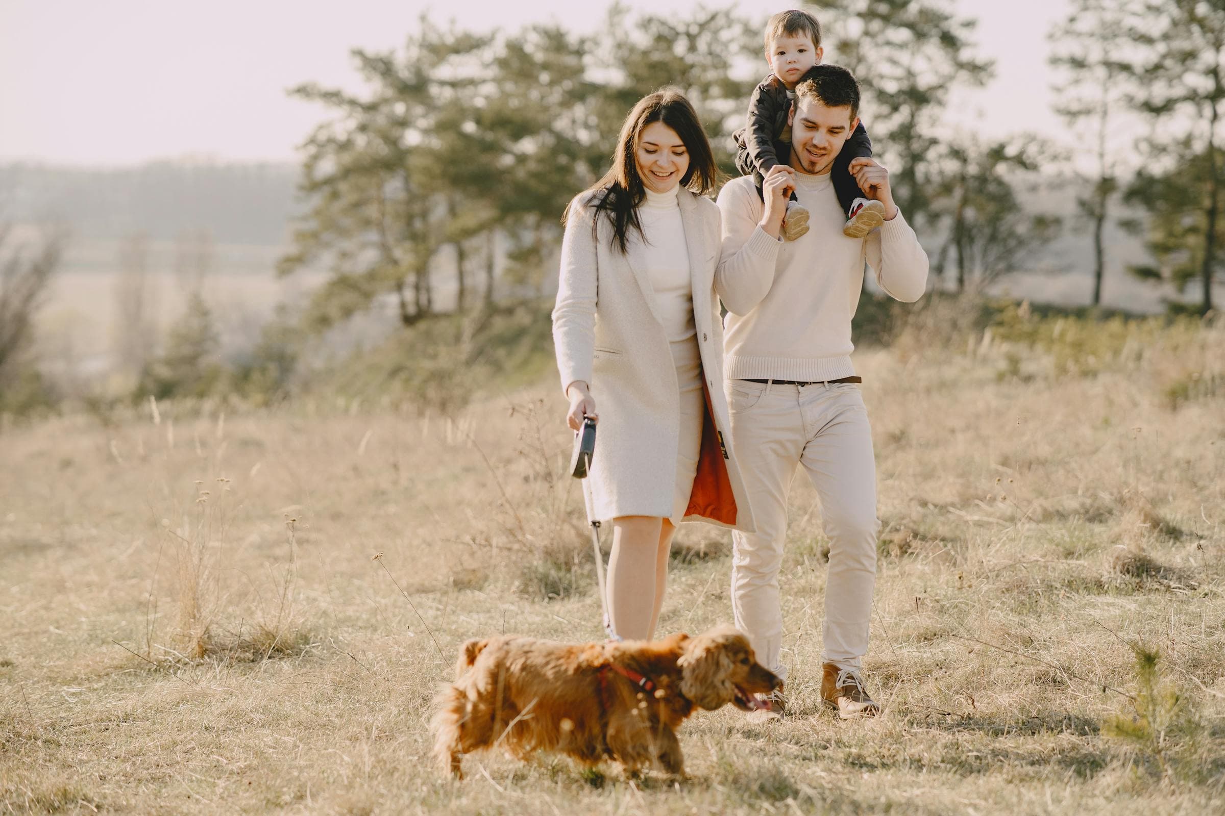 NJ family walking with their dog on a grass field